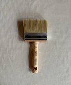 Paint brush with wooden handle on a light gray background
